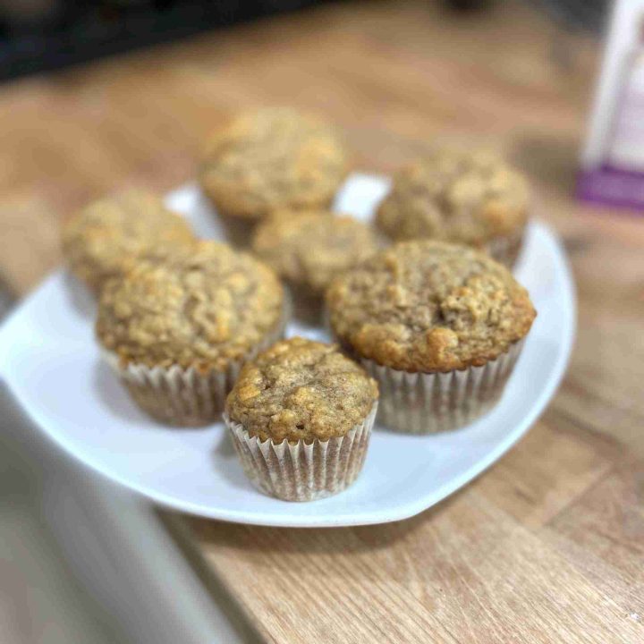 banana muffins on white plate against butcher block counter